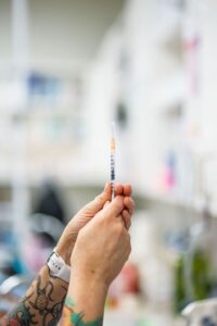 hands drawing medicine into a syringe