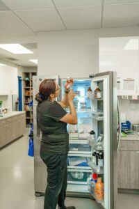 vet tech at Dr.Kelly's filling up a syringe with vaccine