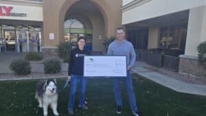 Dr. Kelly's Surgical Unit team presenting a donation check to AZ Husky Rescue outside a clinic. Supporting local animal rescues.